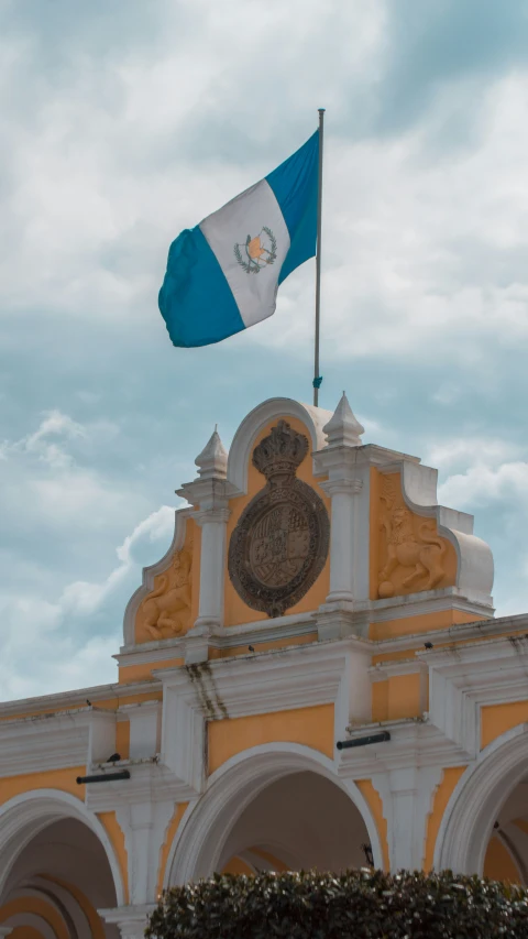 a large flag on top of an old building