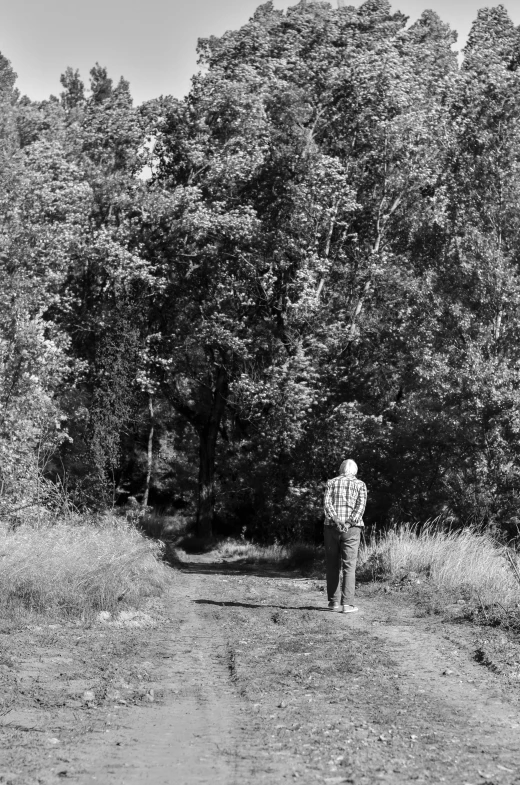 black and white po of a man standing in front of trees