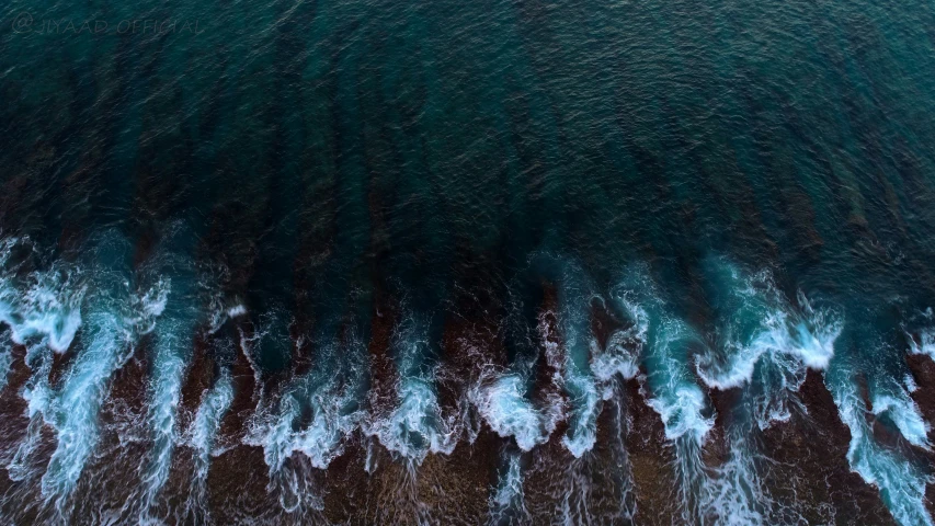 aerial po of sea waves crashing into the beach