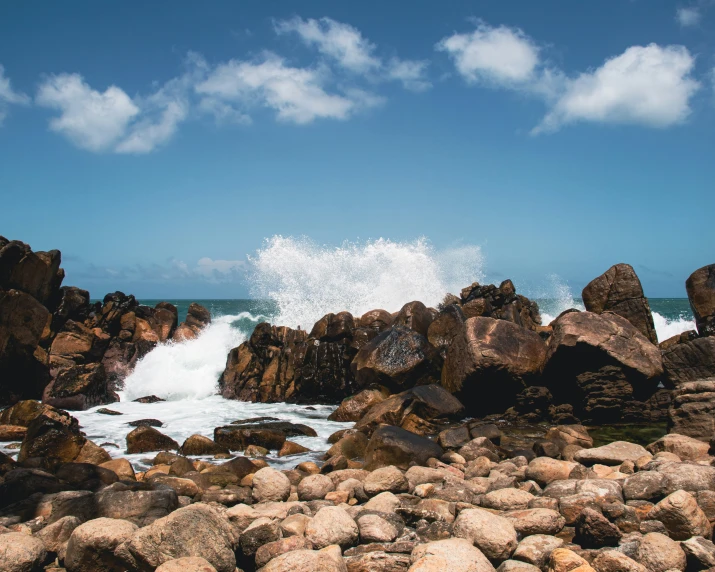 rocks are by the ocean with waves coming in