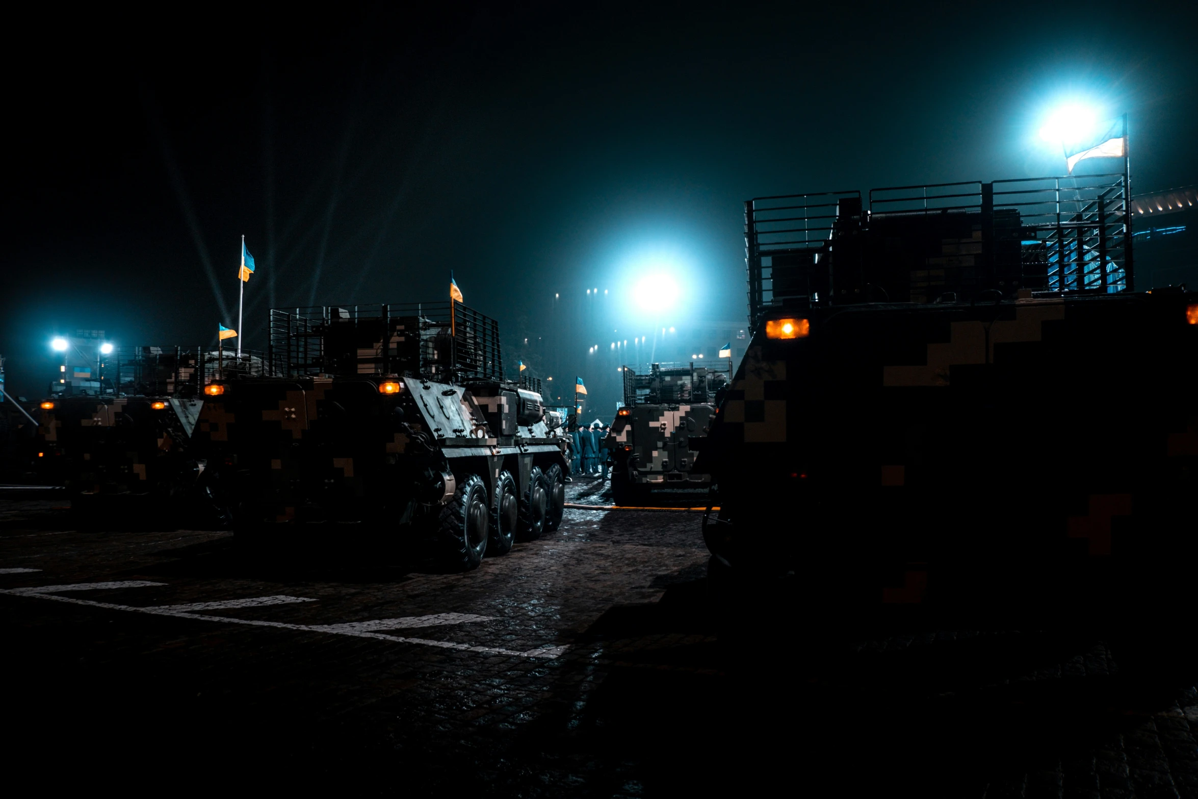 a large group of military vehicles parked in front of an airport