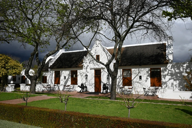 white houses with a thatched roof and several trees