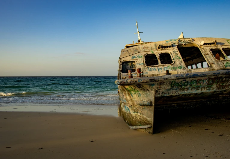 the old boat sits on the shore of the beach