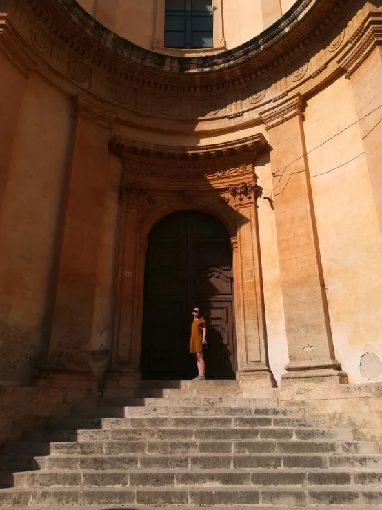 there is a woman standing on the steps to an old church