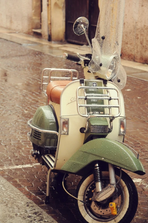 a moped is parked on a stone road