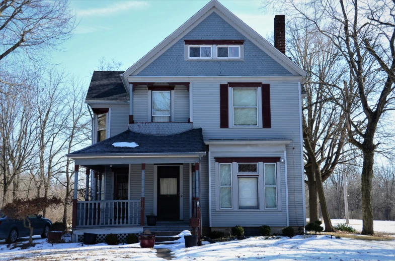 a large house covered in snow with no cars parked