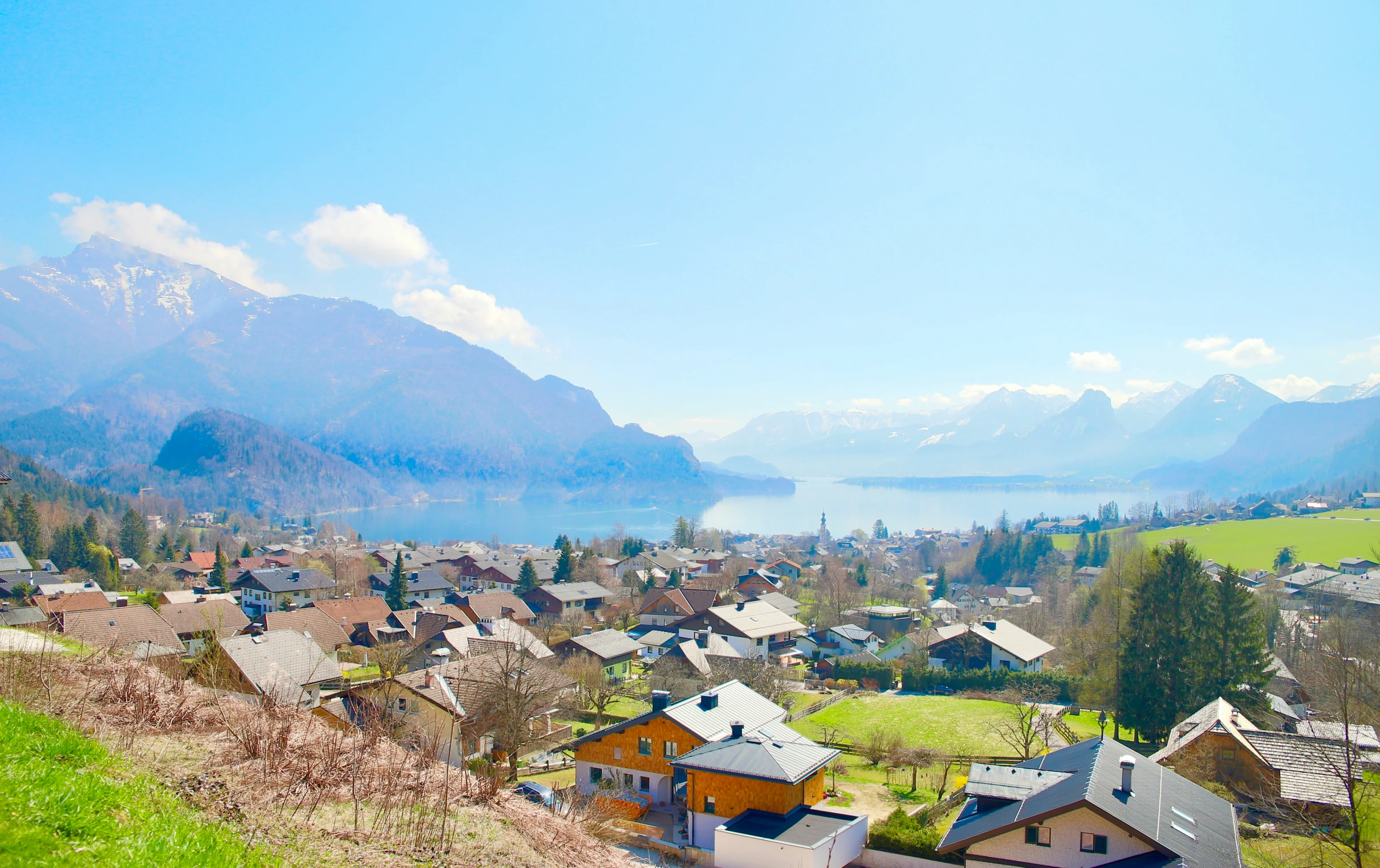 small town nestled on green mountain with beautiful view