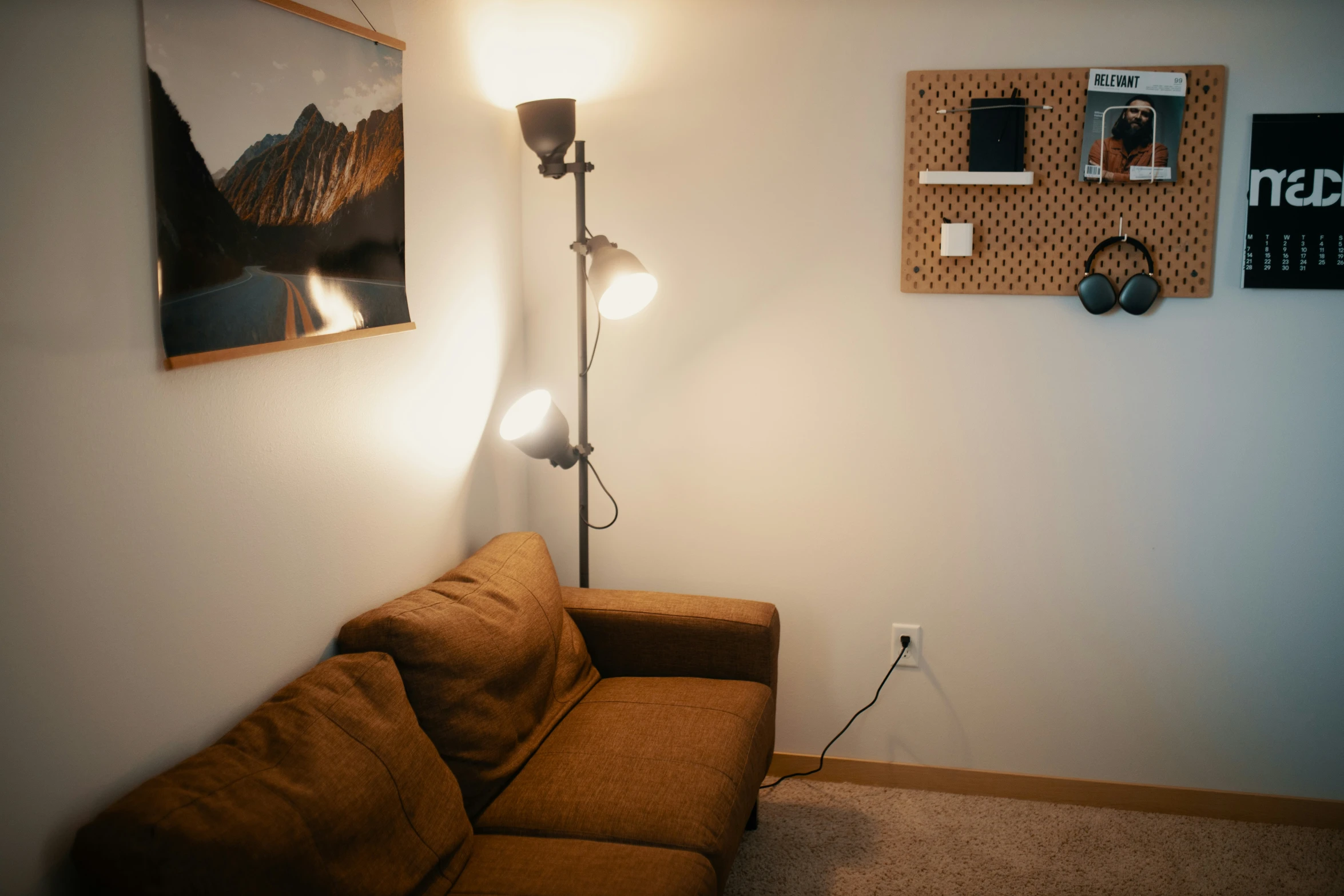 a couch with a light, and some pictures above it