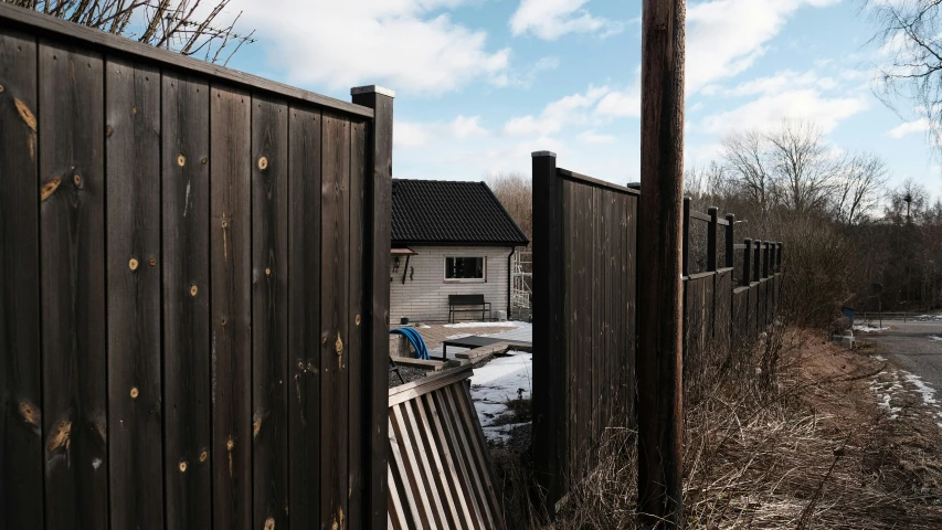 a house in the background behind a fence that is open