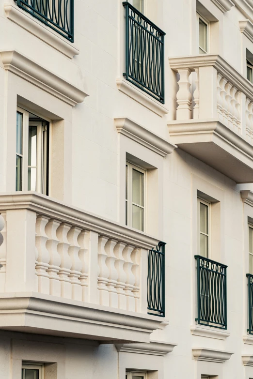 an apartment building is white with black wrought iron balcony railings