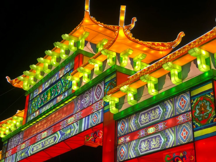 a red archway with yellow and green lanterns on top