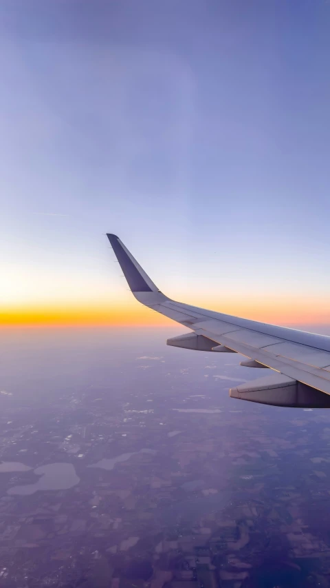 a plane is flying over the earth at sunrise