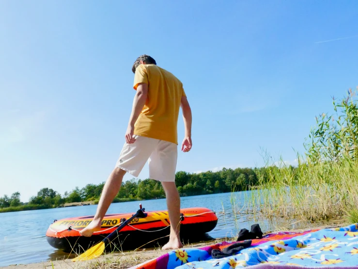 man in yellow shirt standing by boats on water