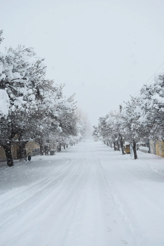 the road is covered with fresh snow from a winter storm