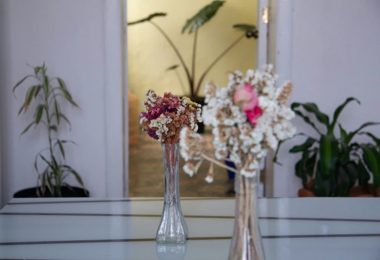 a couple of vases with flowers in them on a table
