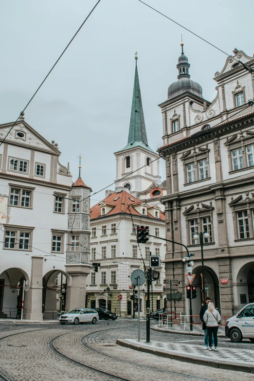 some people are walking down some streets with some buildings