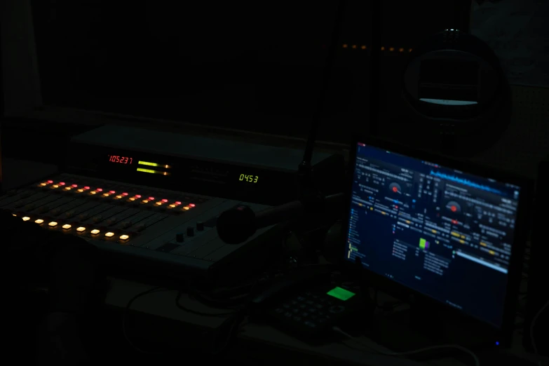 an image of control console with sound board lit up in the dark