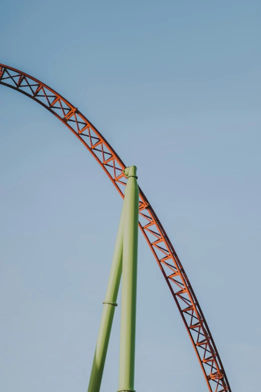 an airplane flying high in the air near the roller coaster