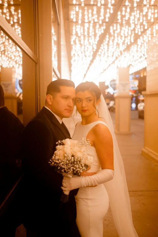 a couple poses for the camera in their wedding dress