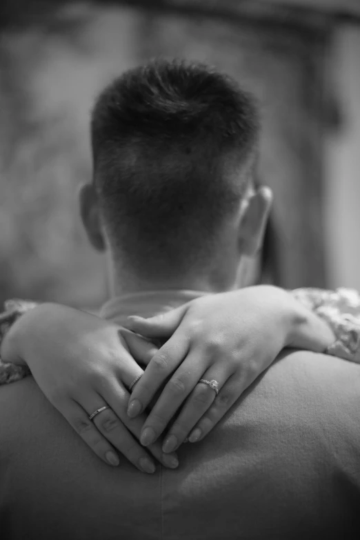 the groom hugs his bride as they are sitting on a couch