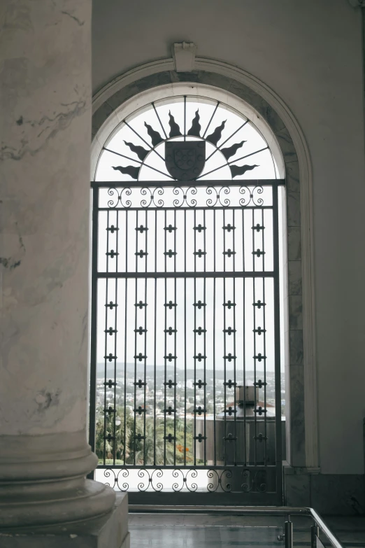 an iron gate with decorative designs and a building