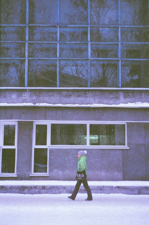 a person walking down a street under some glass