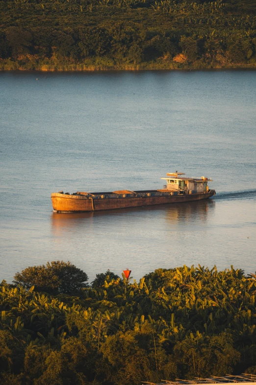 a large boat cruising on a river in the afternoon