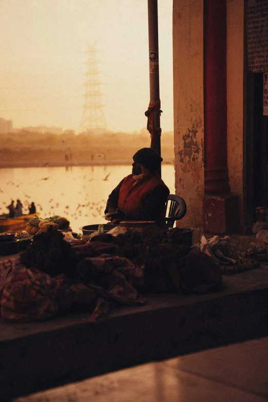 people stand in front of a food market as the sun sets