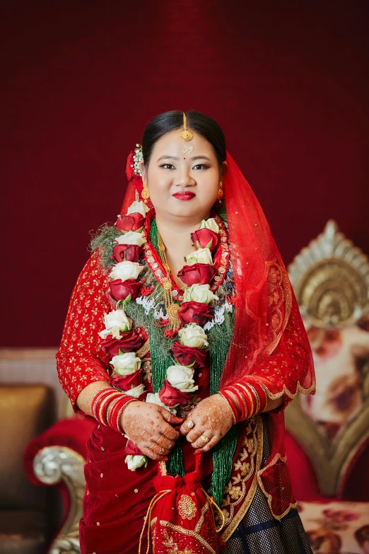 woman in red dress dressed in a veil and decorated with flowers