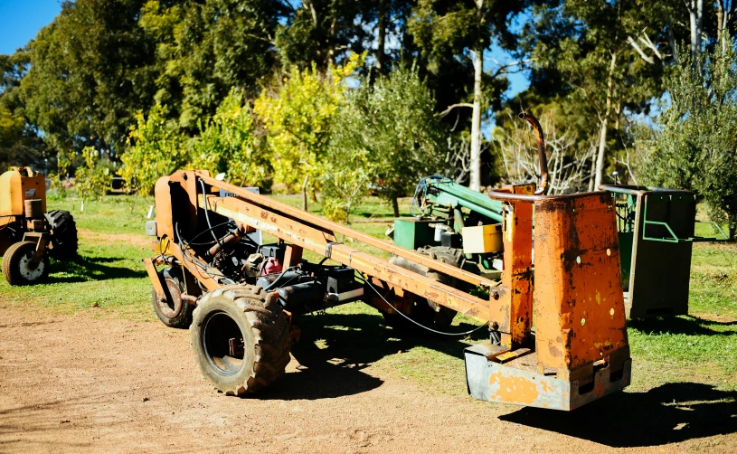 two tractors and an old machinery sit parked together