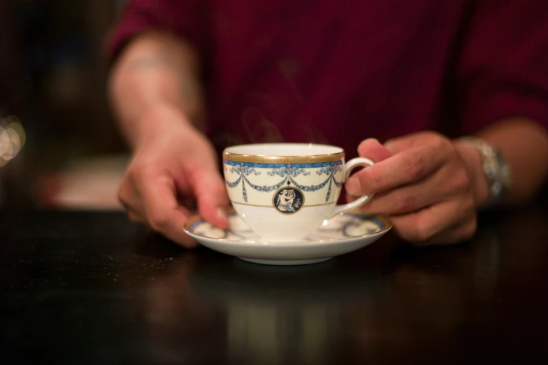 a woman is holding a tea cup in her hand