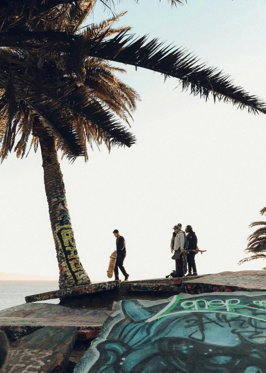 three people walk on the edge of a cement ramp