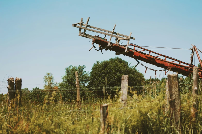 a big red bridge suspended above a field