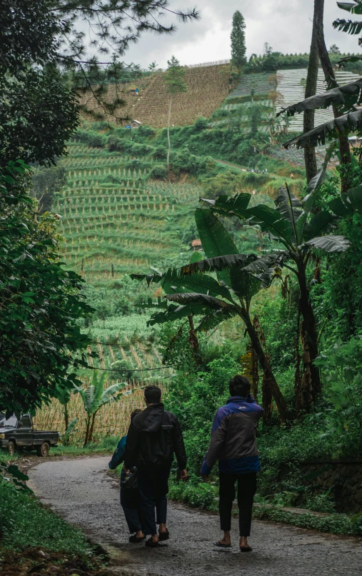 a group of people walking down a dirt road