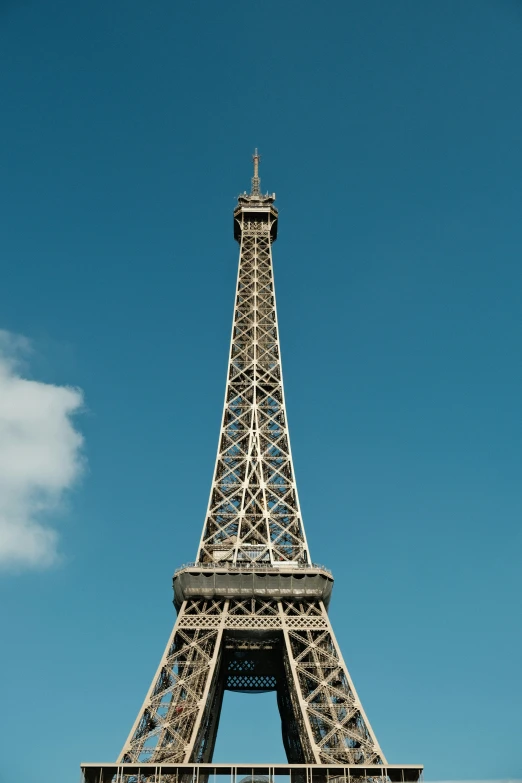 the eiffel tower is sitting tall in front of a bright blue sky