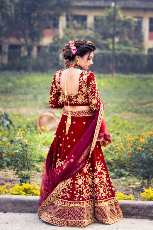 a beautiful bride in a maroon and gold lehenga and maroon saree