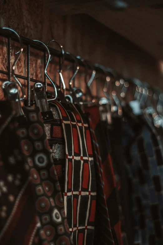 a row of ties on display on a rail