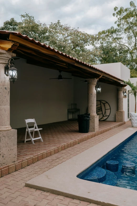 a chair sitting next to the pool with trees around