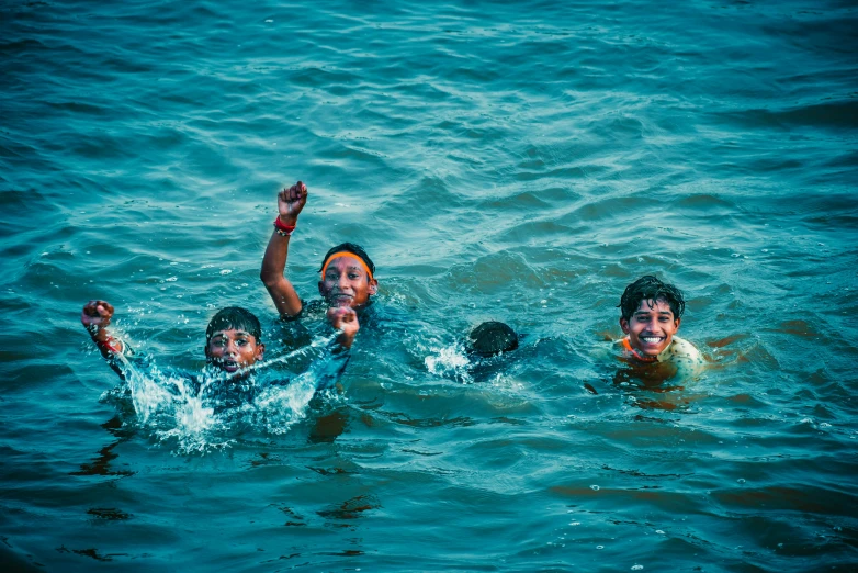three children playing with an object in the water