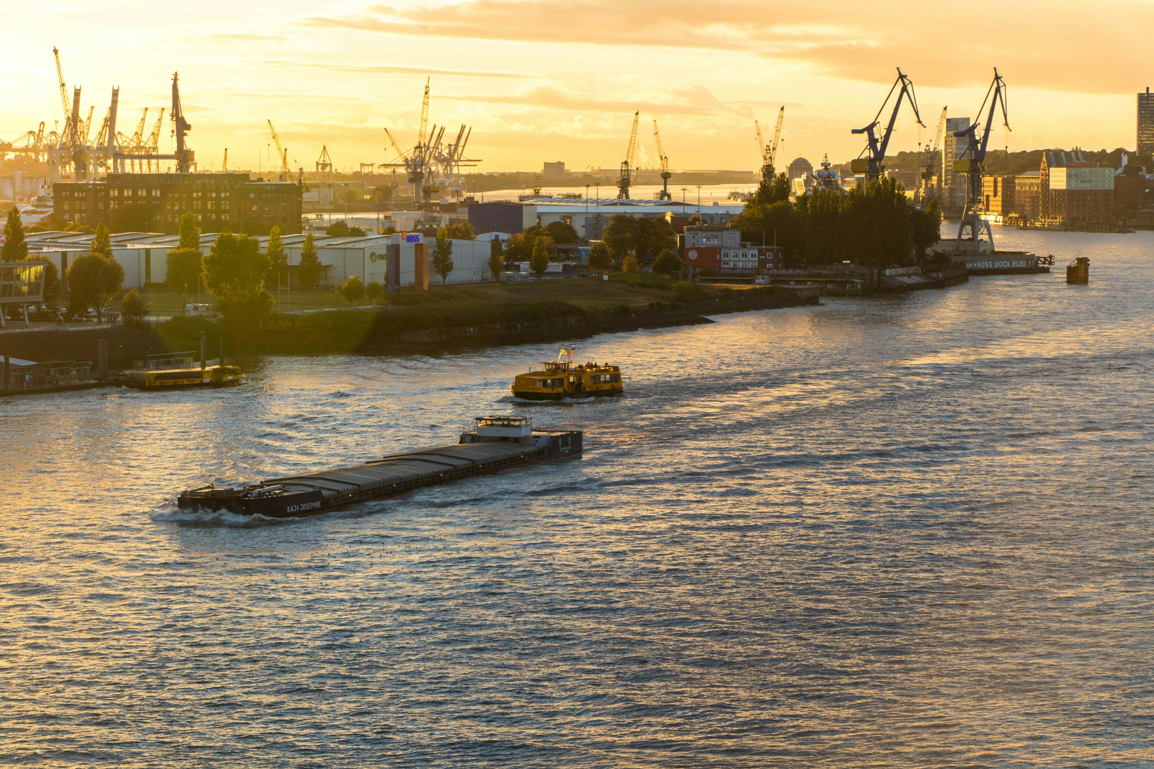 a long barge is in the water near ships