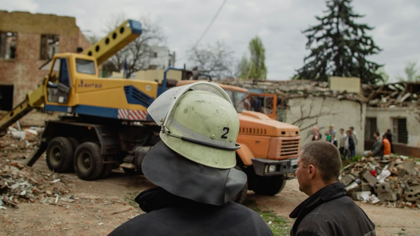 a couple of men standing in front of a large truck