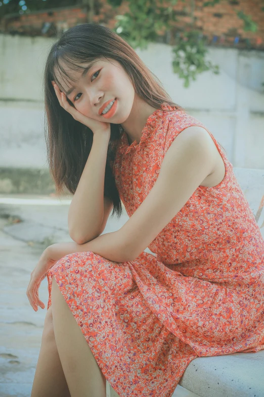 the woman wearing a red dress is sitting on the cement