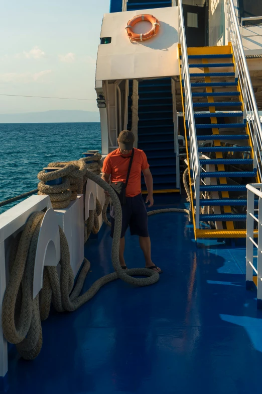 man standing on deck of boat with giant snake wrapped around him