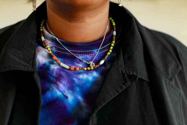 a woman wearing a colorful necklace and shirt