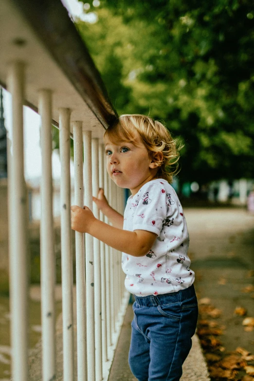 a little girl holding her hand on the railing