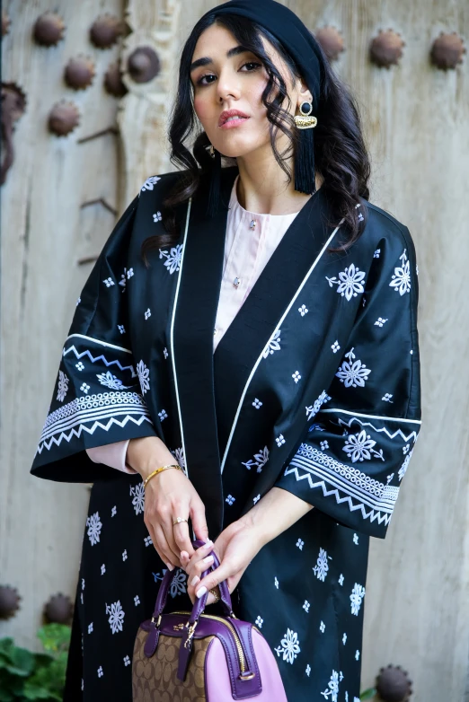 a woman in an ethnic dress with her hand bag