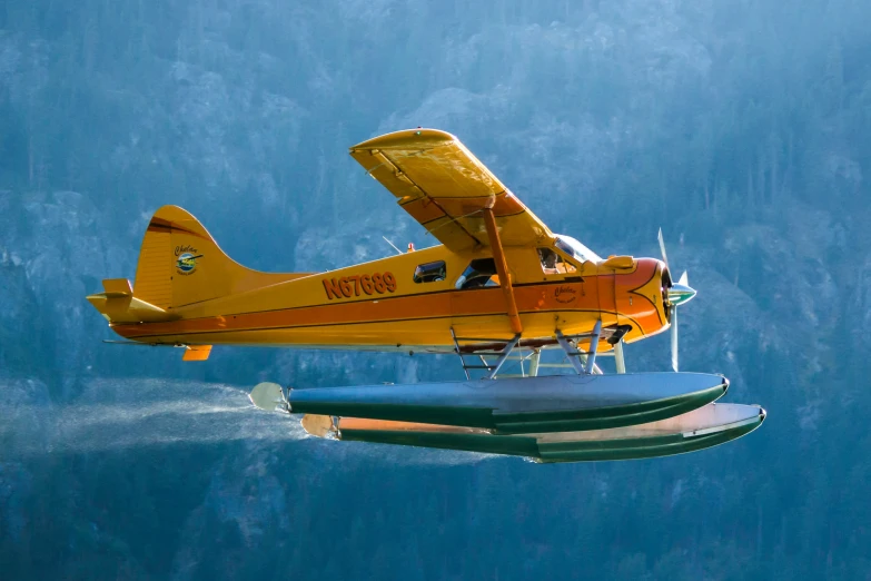 an orange airplane flying through a blue sky