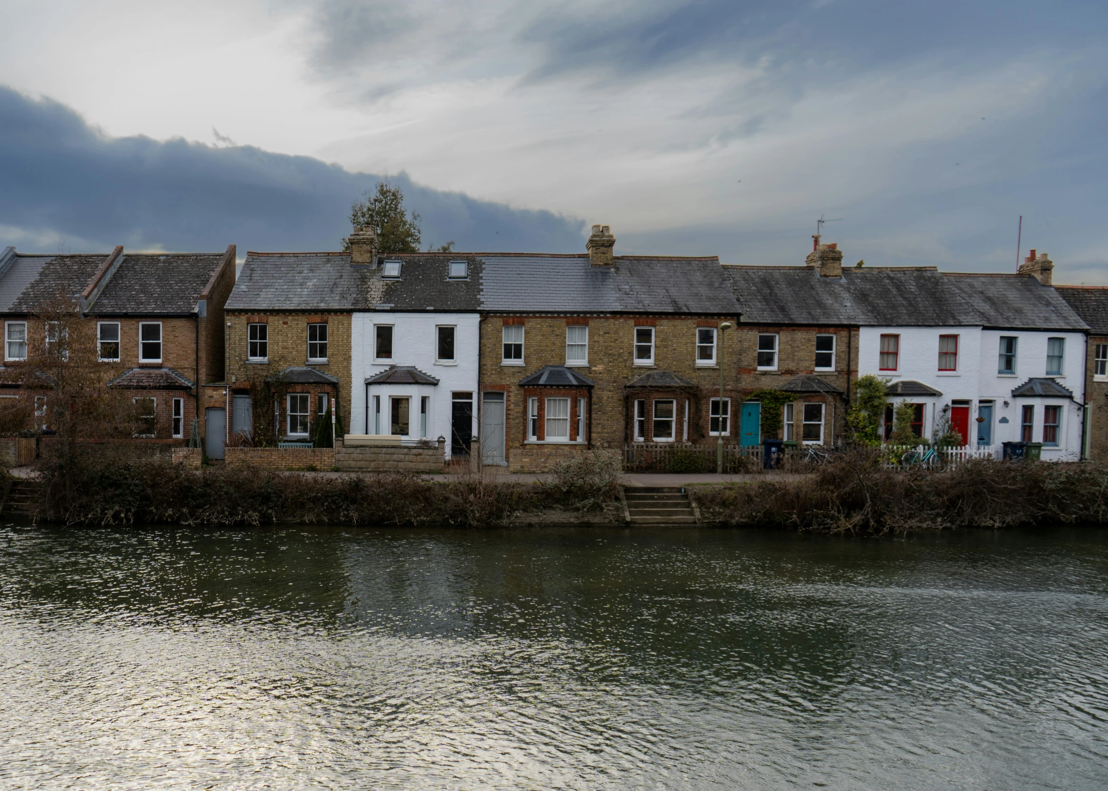 a group of houses by the water with rain