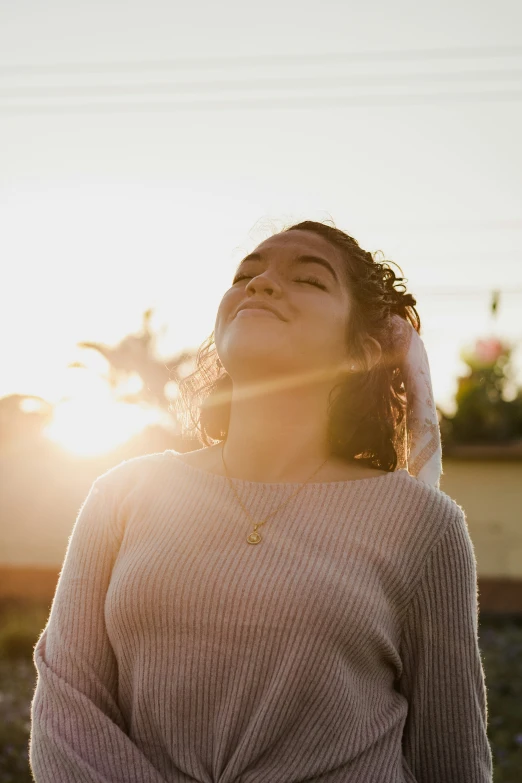 a woman standing outside in front of the sun