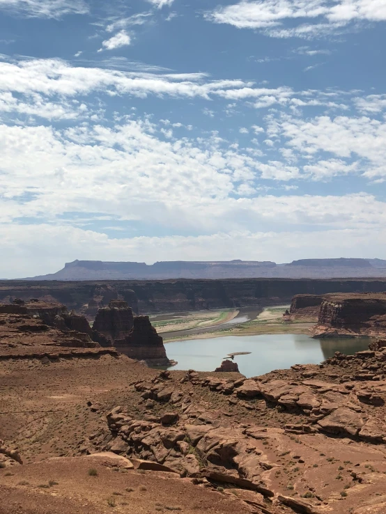 a large pond is sitting below some rocks